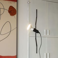 a light that is sitting on the wall next to a book shelf and cupboards