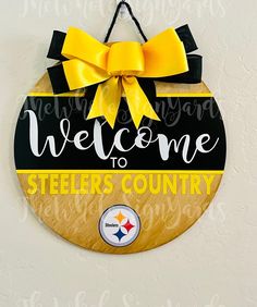 a welcome to steeles country sign hanging on a wall with a yellow bow around it