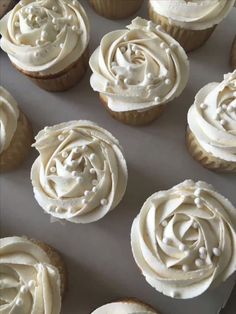 cupcakes with white frosting sitting in a box