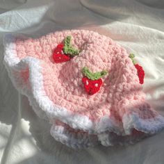 a crocheted hat with two strawberries on it