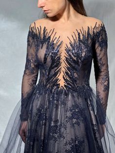 the back of a woman's dress with long sleeves and an intricate lace pattern