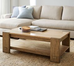 a wooden coffee table sitting on top of a carpeted floor next to a couch