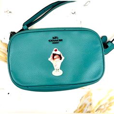 This Stylish Crossbody Bag By Coach Is A Must-Have For Any Fashion-Savvy Woman. The Bag Features An Eye-Catching Green Handle/Strap And Blue Hardware That Perfectly Complements The Cream-Colored Leather Exterior. The Bag's Interior Is Lined With A Gorgeous Shade Of Green That Adds To Its Appeal. The Bag's Compact Size Makes It Perfect For Carrying All Your Essentials Without Weighing You Down. It's Ideal For Everyday Use Or For Special Occasions. The Coach Blue Green Leather Ice Cream Sundae Cro Coach Crossbody Bag With Cell Phone Pocket, Coach Shoulder Bag With Cell Phone Pocket, Coach Pouch Bag With Cell Phone Pocket, Coach Crossbody Shoulder Bag With Cell Phone Pocket, Coach Crossbody Mobile Phone Bag, Coach Mobile Phone Pouch Bag, Coach Mobile Phone Crossbody Bag, Coach Shoulder Bag For Mobile Phone, Coach Mobile Phone Bag For Daily Use