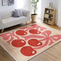 a living room with a white couch and red rugs on the wooden flooring