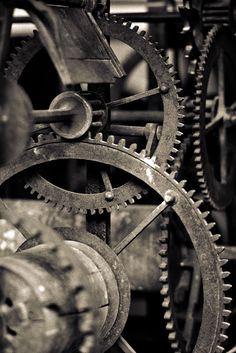 black and white photograph of gears on an old clock tower, with focus on the gear