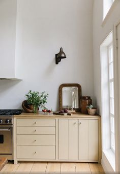 a kitchen with white walls and wooden floors