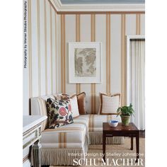 a living room with striped wallpaper and furniture in the corner, along with a painting on the wall