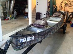 a boat is parked in a garage next to some bikes and other things on the floor