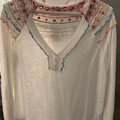 White Cotton Blouse With Multi-Colored Embroidered Detail On Collar And Back. Brand New, Never Worn. White V-neck Top With Intricate Embroidery, White V-neck Blouse With Intricate Embroidery, White Embroidered Long Sleeve Top, White Long Sleeve Top With Embroidered Hem, White Long Sleeve Blouse With Embroidered Hem, White Long Sleeve Tops With Geometric Embroidery, White Long Sleeve Tops With Floral Embroidery, Casual Multicolor Tops With Embroidered Sleeves, White Long Sleeve Tops With Intricate Embroidery