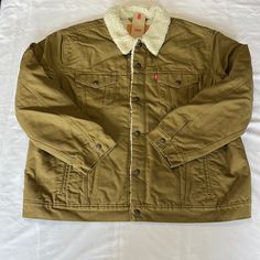 Levi’s Type 3 Canvas Sherpa Jean Jacket In Dark Khaki Size Xxl. New With Tags! Snap Front Closure, Snap Flap Chest Pockets, Front Welt Pockets, Snap Cuffs, Snap Adjustable Back Tabs, Dark Khaki With Cream Colored Sherpa, Inside Chest Pocket Measurements Laying Flat-Pit To Pit=29”, Sleeve Length Shoulder Seam To Cuff=26”, Shoulder To Shoulder Seams Across The Back=22”, Length From Bottom Of Back Collar Seam To Hem=27.5” Casual Khaki Outerwear With Fleece Lining, Brown Sherpa Outerwear With Pockets, Levi's Khaki Outerwear With Pockets, Levi's Brown Winter Outerwear, Levi's Cold Weather Outerwear With Pockets, Levi's Outerwear With Pockets For Cold Weather, Levi's Long Sleeve Utility Outerwear, Levi's Long Sleeve Outdoor Outerwear, Winter Khaki Outerwear With Corduroy Collar