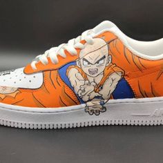 an orange and white nike air force is painted with dragon ball characters on the side