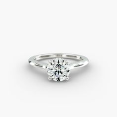 a round brilliant cut diamond engagement ring on a plain white background, with the center stone set in 18k white gold