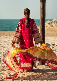 Red Lawn Kameez Yellow Dupatta for Pakistani Party Wear is a crimson front-open shirt that is as lovely as a pure jewel hue and has composed sleeves. A combination of processing techniques is used to create gorgeous silk embroidery patches in contrasting colors on the sleeves. On a flowy lawn shirt, the front organza border is exquisitely pre-worked to enhance the look. It has a geometrical published silk finish inside the shirt. It is pared with cambric palazzo pants with embellished organza pa Red Dupatta With Dabka Work, Festive Red Kurta With Dupatta, Designer Traditional Red Wear For Eid, Red Designer Traditional Wear For Eid, Designer Traditional Wear For Eid In Red, Bollywood Style Red Kurta For Festive Occasion, Red Bollywood Kurta For Festive Occasion, Festive Red Kurta, Festive Red Dupatta With Dabka Detail