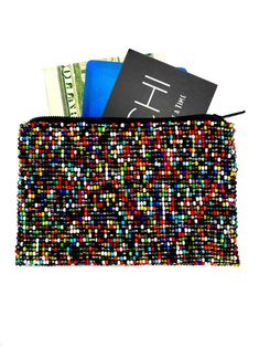 a wallet is filled with money and some sort of credit card holder that looks like it's made out of beads