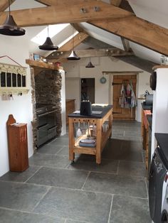 a kitchen with stone flooring and wooden beams on the ceiling is pictured in this image