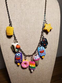 the necklace is decorated with colorful items on it's chain and has an owl charm