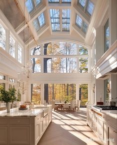 a large kitchen with an arched ceiling and white cabinetry, along with windows that allow natural light to the room