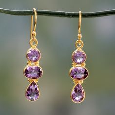 Brilliant 22k gold vermeil hosts ethereal lilac gemstones in these dangle earrings from India's Alok Jain. The trio of gems, which represents February´s birthstone, features oval, round, and pear-shaped amethysts totaling a sumptuous 15 carats. Amethyst Set, Ear Clips, Amethyst Gold, Gold Overlay, Birthstone Earring, Unique Handmade Jewelry, Amethyst Earrings, Dream Jewelry, Exquisite Jewelry