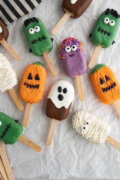 there are many halloween treats on the table together, including marshmallows and pops