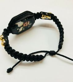 Pulsera hecha a mano de Jesus Malverde doble tejida con hilo reforzado en color negro y bolas chapeado en oro laminado es una pulsera ajustable para hombre o mujer material: hilo reforzado#18 color negro bolas dorado 8mm en oro laminado tableta de madera color negro con imagen de Jesus Malverde por ambos cubierta con resina para no despintarse en cuando suda al usarse Tambien se puede hacer de diferente color de hilo, preguntenos!! porque lo hacermos la pulsera en cuando lo ordena Adjustable Braided Gold Bracelets, Handmade Adjustable Braided Bracelets As Fashion Accessory, Adjustable Gold Braided Jewelry, Adjustable Braided Gold Jewelry, Adjustable Gold Rosary Bracelet As Gift, Handmade Adjustable Friendship Bracelet, Adjustable Gold Rosary Bracelet For Gift, Gold Hand-strung Friendship Bracelets As Gift, Adjustable Braided Bracelets, Hand-strung, Gift