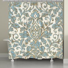 a blue and white shower curtain with an ornate design on it's side, in front of a bathtub