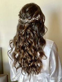 the back of a woman's head with long wavy hair and a tiara