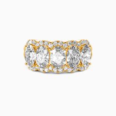 three stone diamond ring in yellow gold with diamonds around the band and sidestones on each side