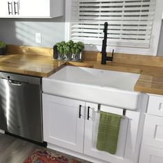 a kitchen with white cabinets and stainless steel appliances, including a dishwasher in the center