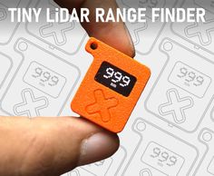 a tiny orange finder in the palm of someone's hand that is holding it