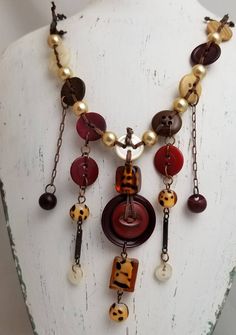 a necklace with buttons and chains hanging from it