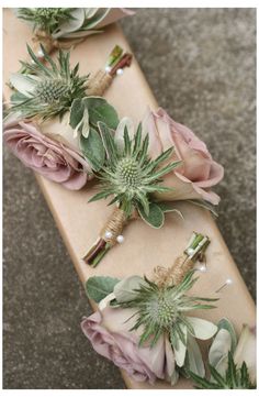 flowers and greenery are laid out on a wooden board