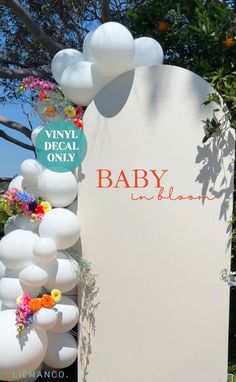 the sign for baby in bloom is decorated with white balloons and colorful flowers on it