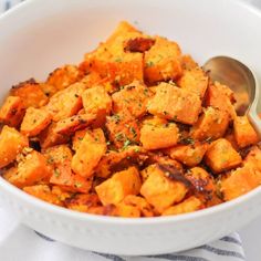 a white bowl filled with sweet potatoes on top of a blue and white table cloth