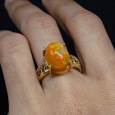 ✨ Experience the Radiance of Fire Opal ✨ Indulge in the luxurious charm of our Fire Opal Gold Ring, a masterpiece of filigree artistry crafted with meticulous attention to detail. This exquisite piece, featuring a Minimalist Opal Ring design, is perfect for those with refined tastes seeking Unique Opal Design, handcrafted jewelry. 🔹 Ring Features: Material: Solid gold with 14k purity, marked by JR14kMX for authenticity. Design: Comfort fit band with an elegant filigree pattern that enhances the unique characteristics of the Mexican Opal Jewelry. Craftsmanship: Handmade using traditional jewelry techniques such as casting, forging, and filigree, qualifying it as Artistic Jewelry. 🔸 Gemstone Insight: Type: Genuine Mexican fire opal, known for its vibrant color and captivating play of light Dragon Breath Fire Opal Jewelry, Opal Ring Design For Women, Mexican Fire Opal Jewelry, Scorpio Jewelry, Custom Gold Rings, Opal Gold Ring, Fire Opal Jewelry, Gold Ring For Women, Mexican Opal