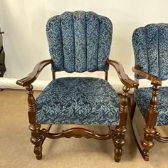 two wooden chairs with blue upholstered fabric