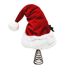 a red and white santa claus hat on top of a metal spiral object with a black bow