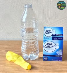 a bottle of water next to a carton of milk and a plastic banana on a table