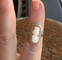 "Antique Edwardian 14k White Gold Filigree Carved Conch Cameo Ring Size 3.75 The item up for offer is a lovely antique Edwardian solid 14k white gold filigree hand carved conch shell cameo ring. The cameo features the bust of a lady and is well defined in its features. This ring is marked \"14k\". Measurements Ring Size: 3.75 (Small! Ask Us About Resizing!) Band Width: 1.6mm Ring Face: 21mm x 12mm Weight: 3.5 g Condition: Excellent; item is pre-owned and may have some signs of light use. Please White Victorian Platinum Rings, Victorian White Platinum Rings, Elegant Carved White Gold Rings, Heirloom White Jewelry Stamped 14k, Art Deco White Ring Jewelry, Art Deco Cameo Jewelry For Anniversary, Formal White Gold Cameo Jewelry, White Filigree Jewelry For Formal Occasions, Formal White Gold Carved Jewelry