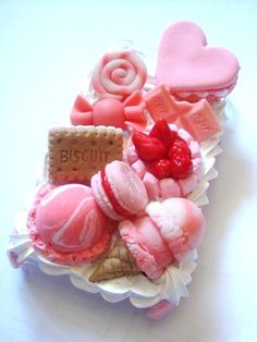 some pink and red desserts are in a cupcake dish on a white table