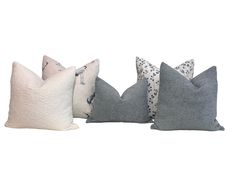 four pillows in different colors and sizes on a white background