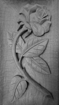 a rose carved into the side of a wooden box with leaves and flowers on it