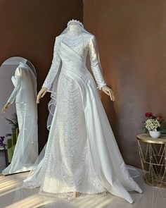 a mannequin wearing a white wedding dress in front of a mirror