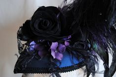 "This unique gothic-victorian masquerade headpiece was inspired by the luxurious Venice Carnival head-dresses. Created in a combination of midnight blue, black and purple. The teardrop base is covered with wonderful two-toned blue and black taffeta. I've used a gorgeous metal \"lace\" mask with rhinestones as the focal point. A glorious bouquet of flowers and feathers create a textured and one of a kind piece. A fluffy black ostrich, along with long iridescent rooster feathers and accents of pur Steampunk Headpiece For Halloween Costume, Vintage Masquerade Costume Accessories For Halloween, Steampunk Headpieces For Masquerade Halloween, Steampunk Headpieces For Halloween Masquerade, Handmade Gothic Costume Hats And Headpieces For Parties, Handmade Gothic Costume Hats And Headpieces, Steampunk Costume Hats For Halloween Masquerade, Vintage Masquerade Mask For Halloween Costume Party, Gothic Masquerade Mask For Halloween Evening