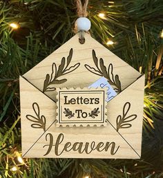 a wooden ornament with the words letters to heaven hanging from a christmas tree