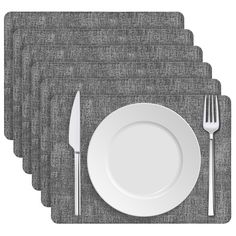 four placemats with silverware on them and one white plate in the middle