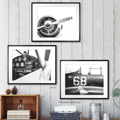 three black and white photographs hang on the wall above a desk with an old typewriter