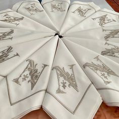 several white napkins with silver designs on them