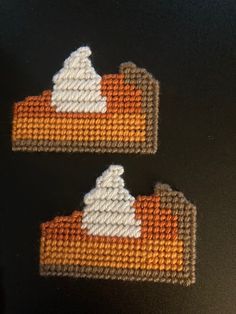 two orange and white pieces of fabric on a black surface with one piece being stitched to the other side