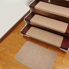 a set of stairs with carpet on the bottom, and two rugs on the bottom