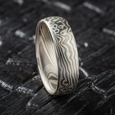 "* Price may vary depending on ring size, please inquire with us directly with your needed size for accurate pricing! Mokume Gane Band - Twist/Droplet Pattern in Droplet palette.  This ring is 6mm with low-dome profile and a satin finish. The ash palette consists of Palladium and Sterling Silver Mokume Gane Band Palette: Ash Pattern: Twist/Droplet Width: 6mm Size Shown: 9 Finish: Satin Profile: Low Dome Price does NOT include stones or setting fees. We care about customer service and would like to hear from you! Please contact us to help create your treasured item, we take your concerns and requests to heart and will work together to create your unique designs SPECIAL PRICING FOR SETS. CONTACT US WITH YOUR DESIRED WIDTHS FOR A QUOTE All Arn Krebs Mokume Gane Rings are CUSTOM and made-to-or Artisan Teardrop Wedding Jewelry, Unique Engraved Wedding Ring With Etched Design, Unique Engraved Ring For Wedding, Unique Engraved Etched Wedding Ring, Artisan White Ring For Wedding, Artisan Engraved Ring For Wedding, Unique Etched Jewelry For Wedding, Artisan Etched Jewelry For Wedding, Modern Engraved Jewelry For Wedding